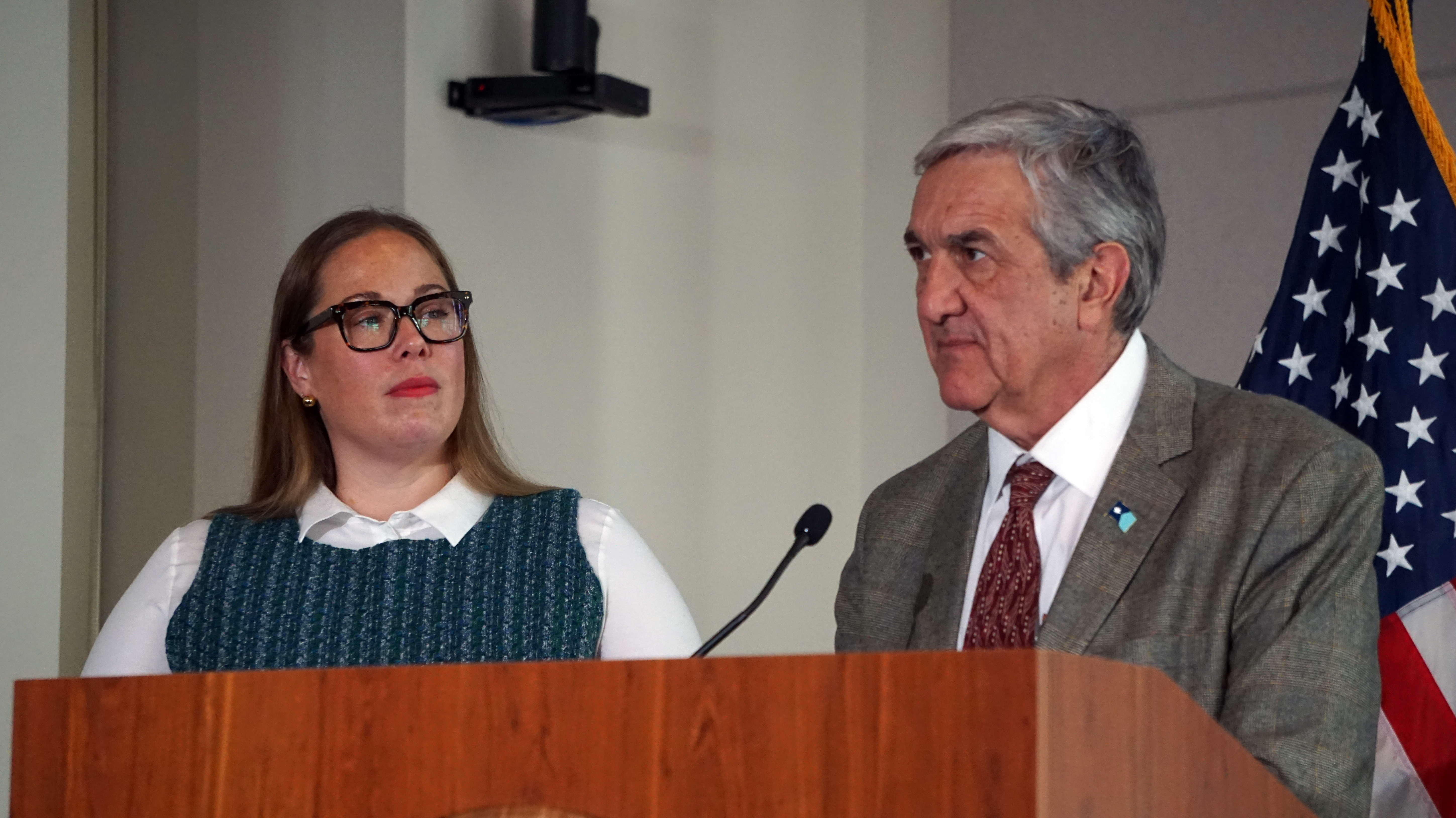 Erin Campbell and Anthony Becker at a lectern.