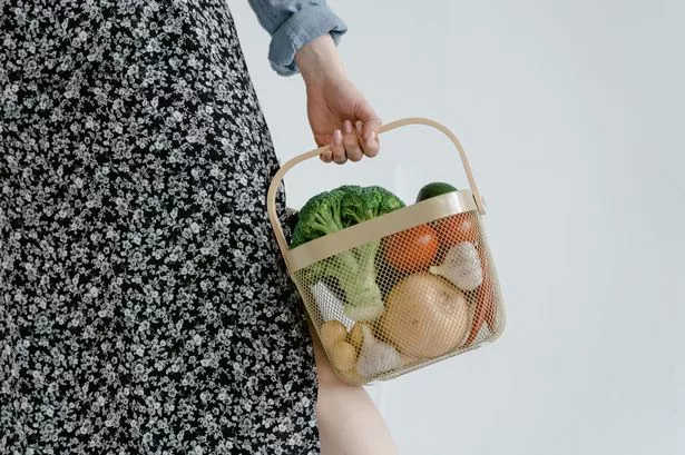 woman with shopping basket of veg