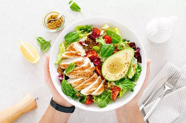 Grilled chicken meat and fresh vegetable salad of tomato, avocado, lettuce and spinach.