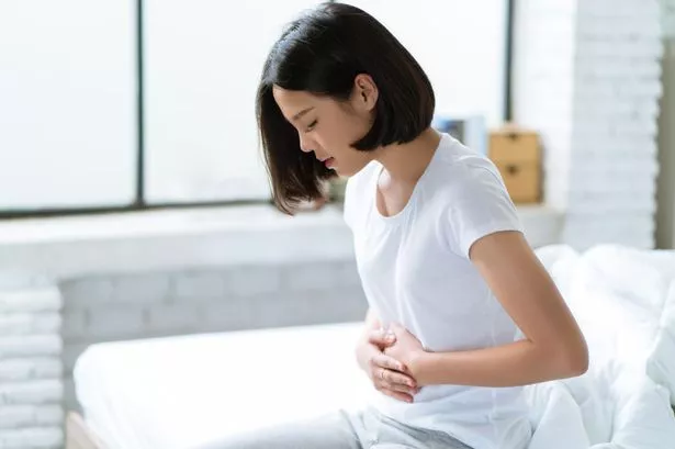 Woman feeling bloated wearing white