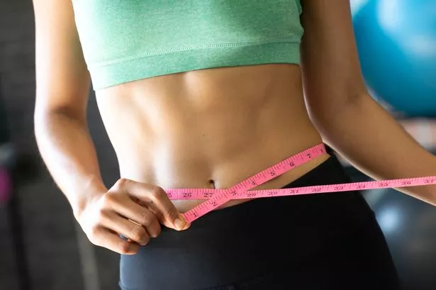 Woman at gym with tape measure