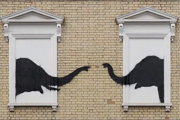 Two elephant head silhouettes painted on a building