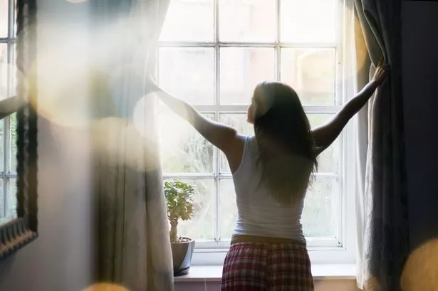 Girl opening curtains