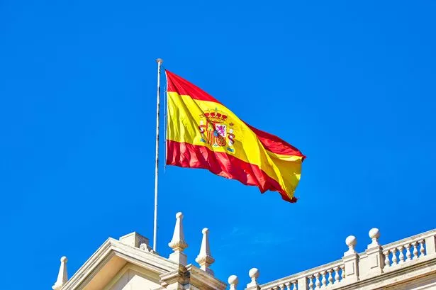 The Spanish flag flying on top of building roof, Spain.