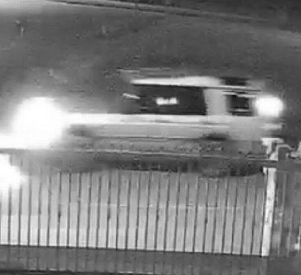 Blurry black and white CCTV footage of a Land Rover