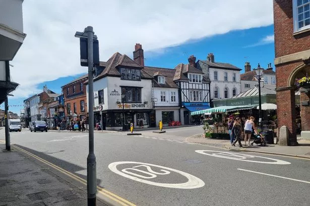 The town of Farnham on a sunny day. The town centre is busy and there are lots of shops.