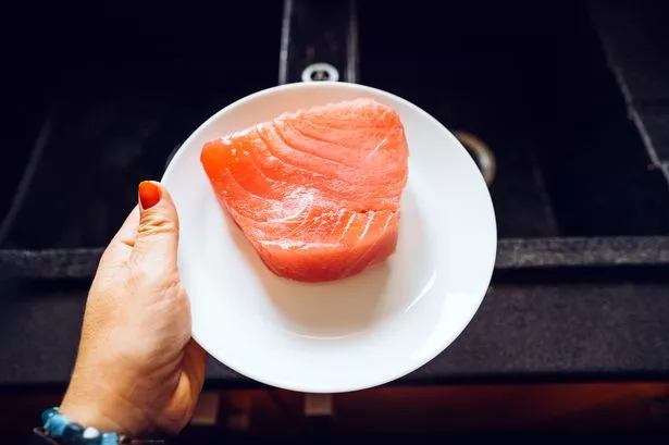 large steak of tuna meat on the plate on the kitchen sink. Healthy nutrition, protein low-calorie diet, gluten free