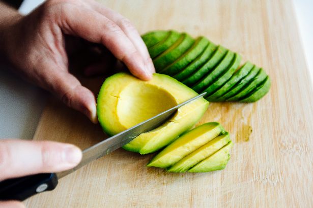 Someone cutting an avocado