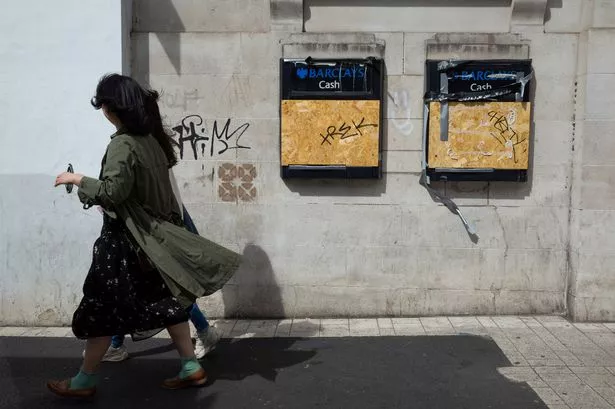 Two women pass by Barclays cash points, both boarded up and vandalised by graffiti, as a leading think tank predicts that surging rates of inflation and weak economic growth in the country could contribute towards a recession, with many households slipping into poverty on 10th May, 2022 in Leeds, United Kingdom. The National Institute of Economic and Social Research (Niesr) has said that a "combination of shocks" could leave the incomes of some "permanently lower". (photo by Daniel Harvey Gonzalez/In Pictures via Getty Images)