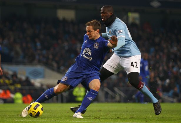 MANCHESTER, ENGLAND - DECEMBER 20:  Phil Jagielka of Everton holds off a challenge from Ya Ya Toure of Manchester City during the Barclays Premier League match between Manchester City and Everton at City of Manchester Stadium on December 20, 2010 in Manchester, England.  (Photo by Clive Brunskill/Getty Images)