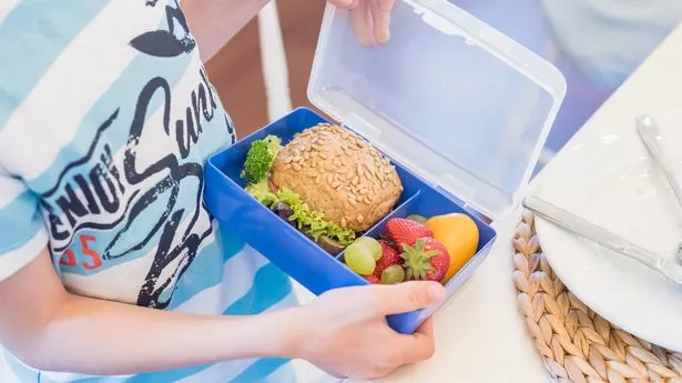 A boy looking at a lunchbox