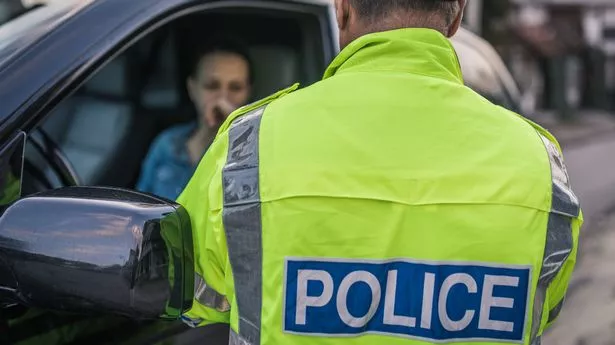 Young woman pulled over by police officer on the road.