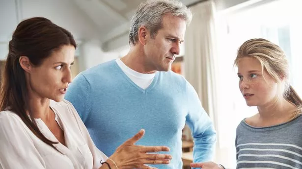 A teenage girl in an argument with her mother and father