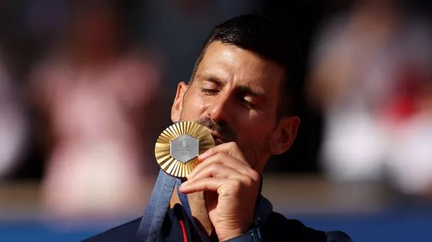 Gold medallist Novak Djokovic of Team Serbia kisses his medal on the podium during the Tennis Men's Singles medal ceremony after the Tennis Men's Singles Gold medal match on day nine of the Olympic Games Paris 2024 at Roland Garros on August 04, 2024 in Paris, France.