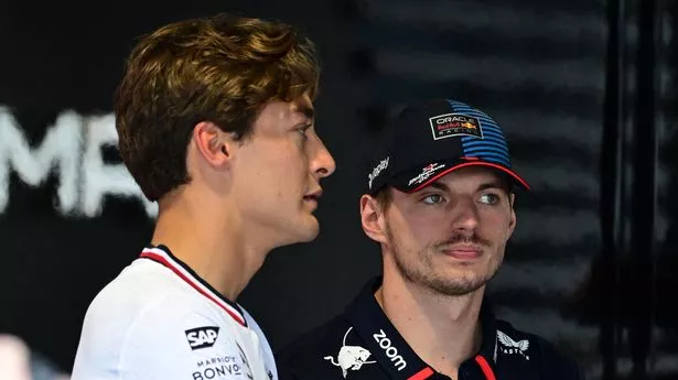 George Russell stands next to Max Verstappen