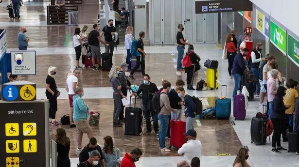 Tourists queue to rent cars upon their arrival at the Reina Sofia Tenerife-South airport on the Canary Island of Tenerife