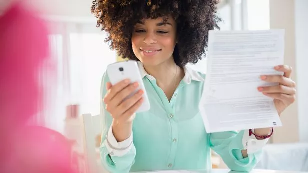 Mixed race woman paying bill with cell phone