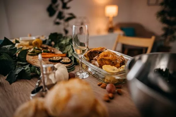 Food and drinks served on table with empty chairs at home