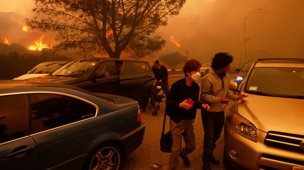 People flee from the advancing wwildfire in Pacific Palisades, Los Angeles