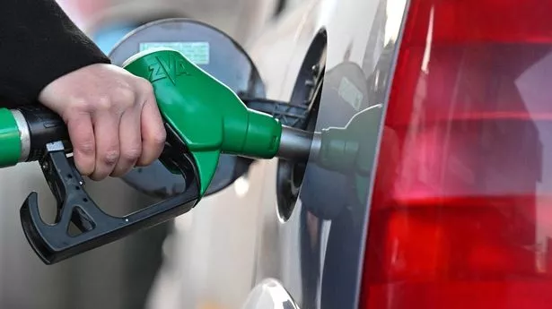 Woman fills up her car at a petrol station