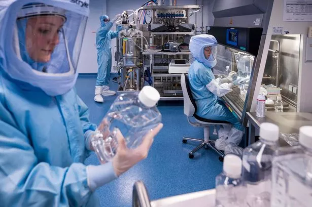 Employees in cleanroom suits test the procedures for the manufacturing of the messenger RNA (mRNA) for the Covid-19 vaccine at the new manufacturing site of German company BioNTech