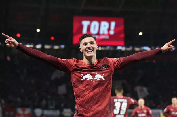 Leipzig's Slovenian forward #30 Benjamin Sesko celebrates scoring his team's first goal during the German first division Bundesliga football match between RB Leipzig and Eintracht Frankfurt in Leipzig on December 15, 2024. (Photo by Ronny HARTMANN / AFP) / DFL REGULATIONS PROHIBIT ANY USE OF PHOTOGRAPHS AS IMAGE SEQUENCES AND/OR QUASI-VIDEO (Photo by RONNY HARTMANN/AFP via Getty Images)