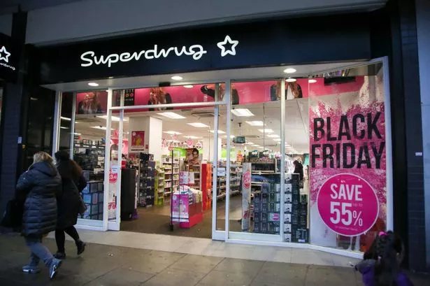 Shoppers are seen walking past the Superdrug store