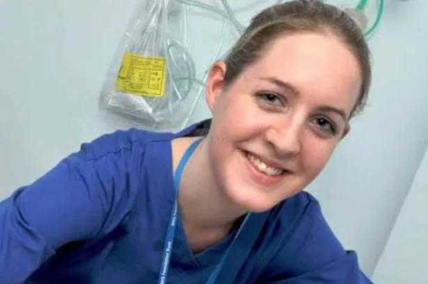 smiling nurse poses with baby