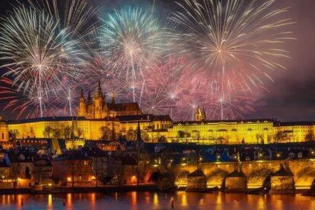 night view of Prague with fireworks in the sky