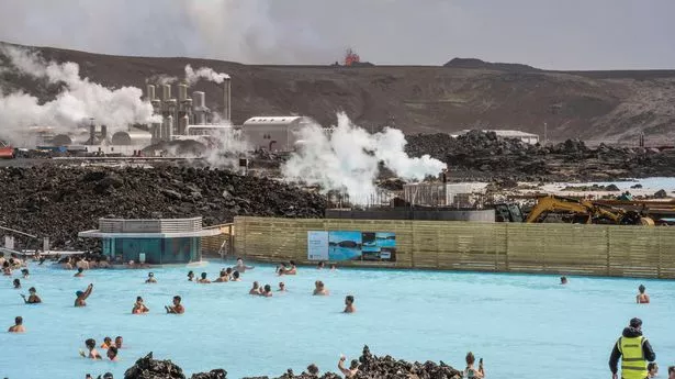 The Blue Lagoon with people bathing in it as the volcanic crater spews lava in the background in Grindavik, Iceland, Sunday, June 2, 2024. The popular Blue Lagoon geothermal spa, one of Icelands biggest tourist attractions in the country's southwest, was reopened Sunday after authorities said a nearby volcano had stabilized after erupting four days earlier. (AP Photo/Marco di Marco)