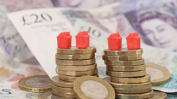 Models of houses on piles of coins and banknotes