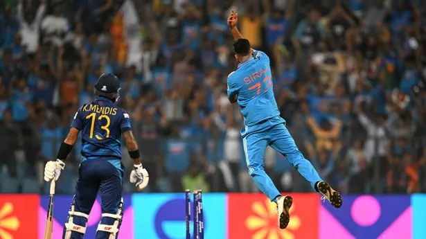 Mohammed Siraj (R) celebrates after taking the wicket of Sri Lanka's captain Kusal Mendis