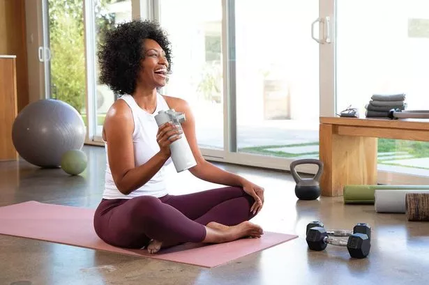 An image of a young woman on a yoga mat with a Ninja Thirsti Water Bottle