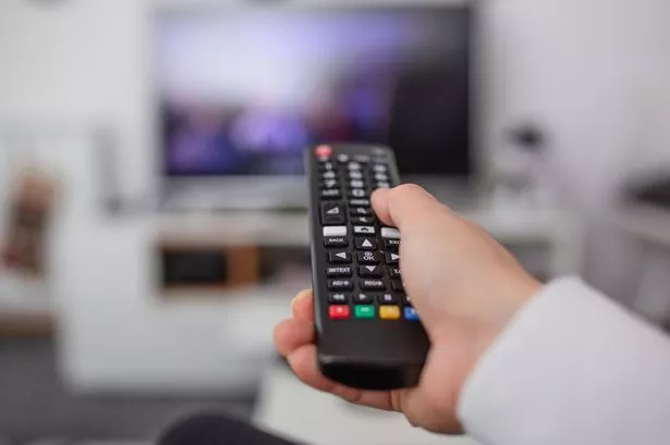 Person holding a tv remote