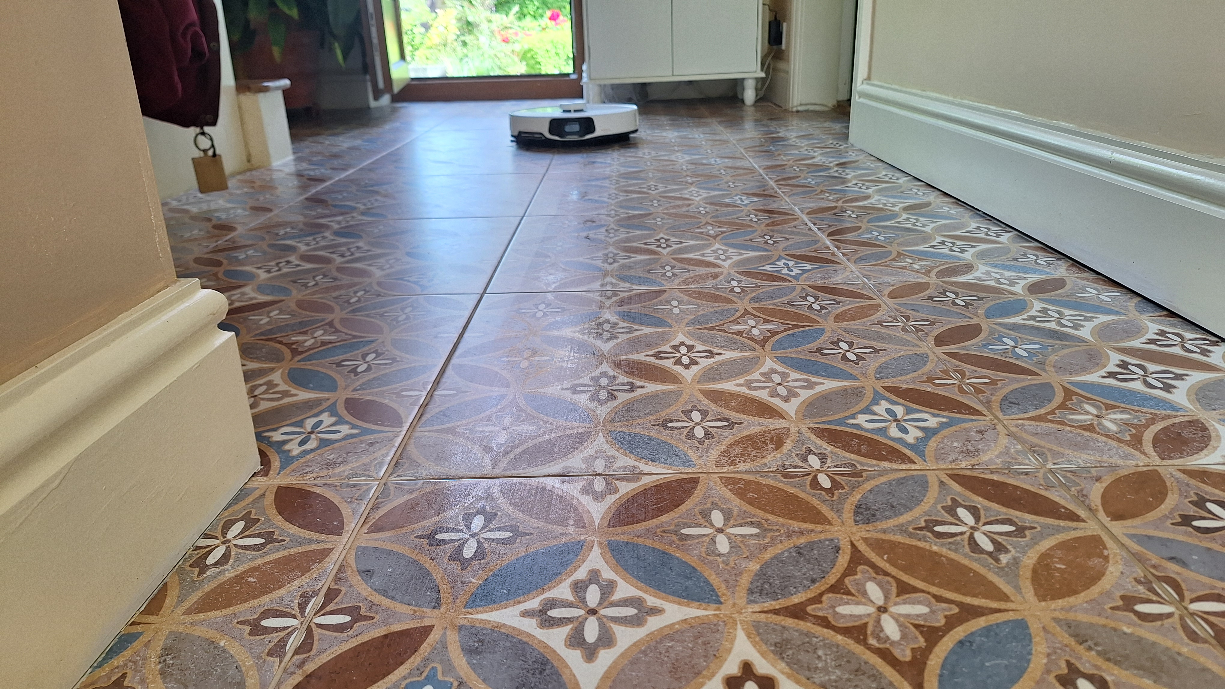 A long view of the Roborock S8 MaxV Ultra mopping a colourful tiled floor