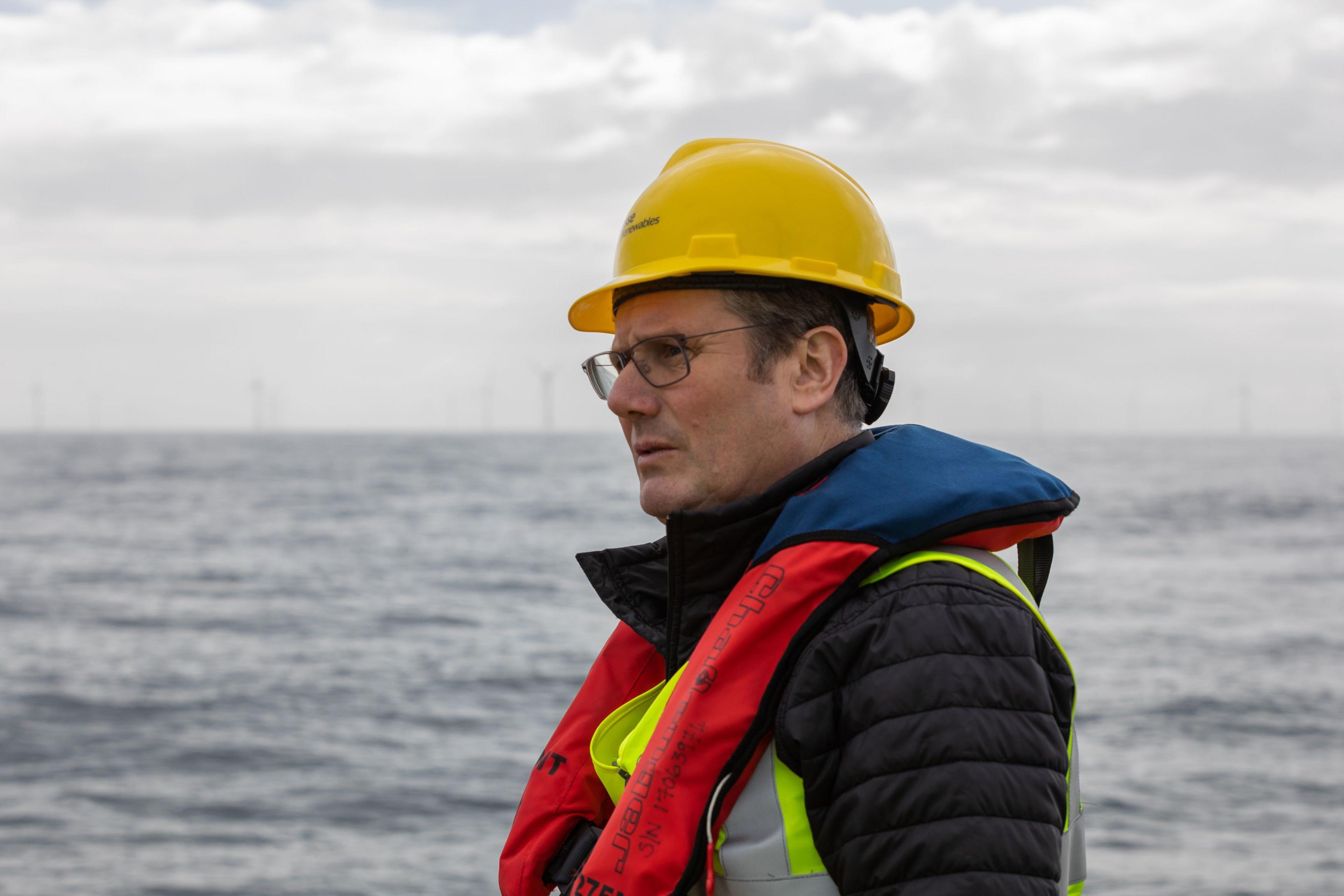 Sir Keir Starmer at sea with wind turbines behind him