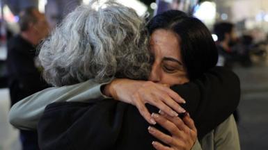 Two women embrace at a public demonstration after ceasefire and hostage deal was agreed