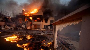 A raging inferno blazes inside the shell of a house