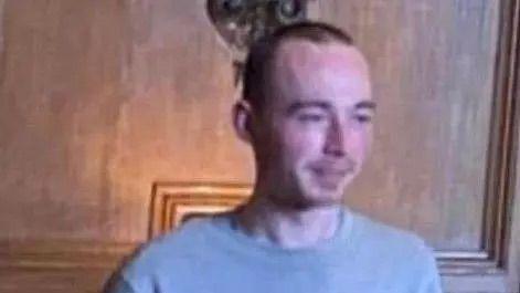 A blurred photo shows missing man Thomas Roche, with short dark hair and stubble, wearing a grey T-shirt.