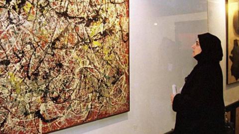 A female visitor views a painting by American abstract expressionist painter Jackson Pollock