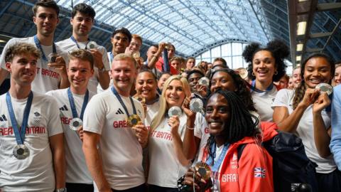 Team GB athletes pose with their medals after disembarking the Eurostar at King's Cross St Pancras station