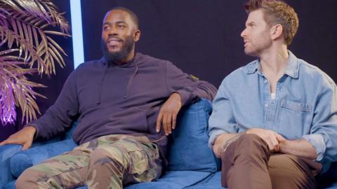 Mo gilligan and Joel Dommett on a blue sofa looking to the left of the image