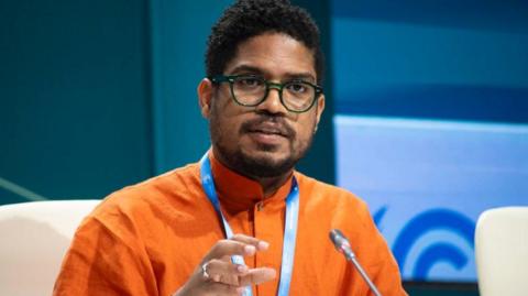 negotiator on podium wearing orange shirt