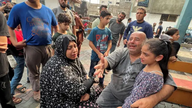 Palestinians react at the damages at a UN-run school sheltering displaced people, following an Israeli strike, in Jabalia in the northern Gaza Strip