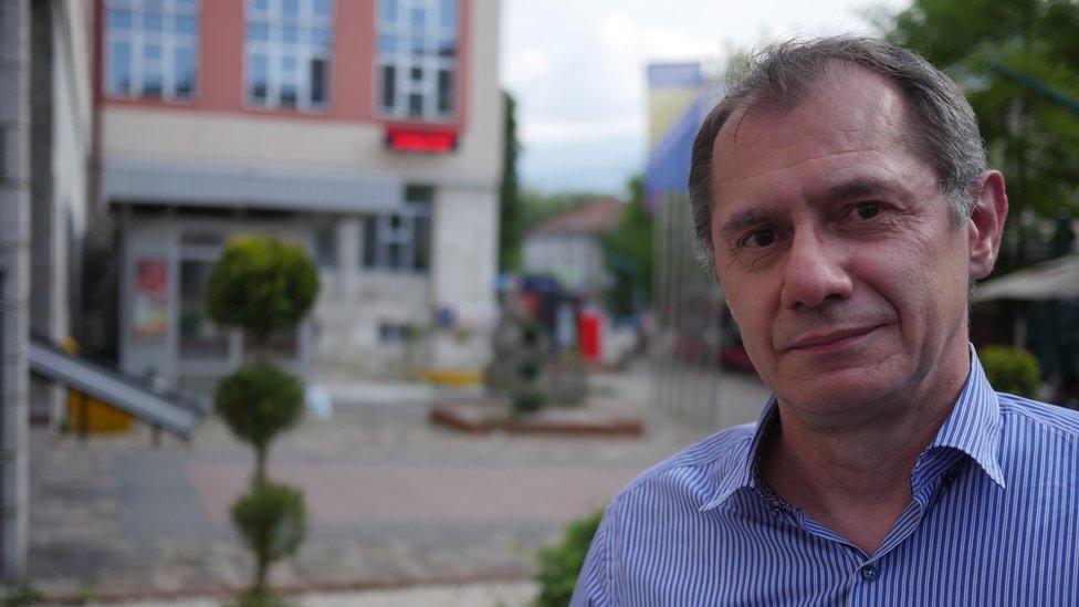 Davor Supa is pictured in a portrait, with the out-of-focus city streets stretching out behind him