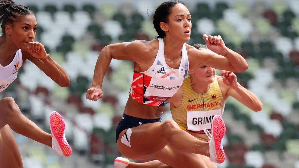 Woman with her leg in front of her jumping over a hurdle