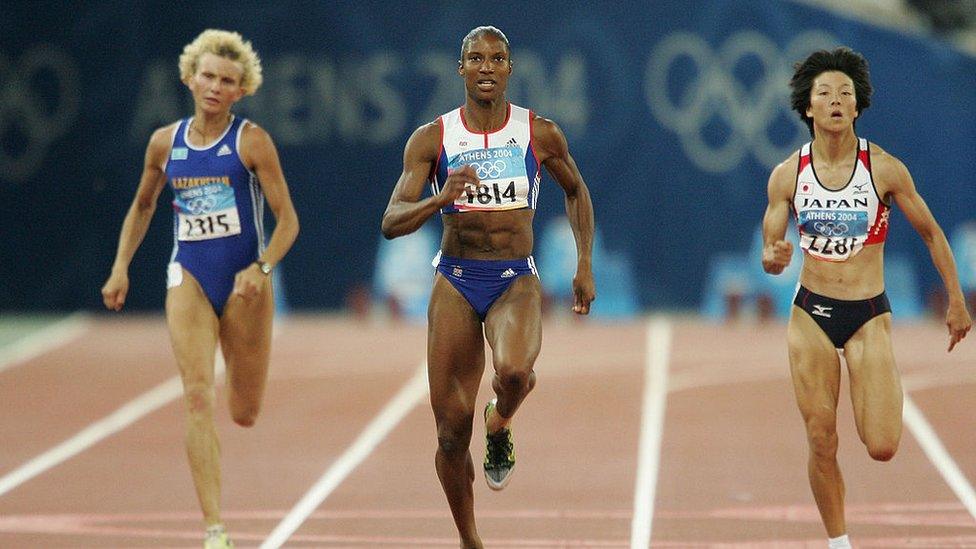 Three women running on an athletic track in separate lanes