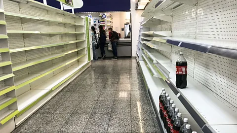 Getty Images Political instability and skyrocketing inflation have led to empty shelves in shops in the capital of Venezuela (Credit: Getty Images)