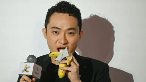 Chinese crypto entrepreneur Justin Sun pictured eating a banana which was part of an artwork he paid $6.2m for