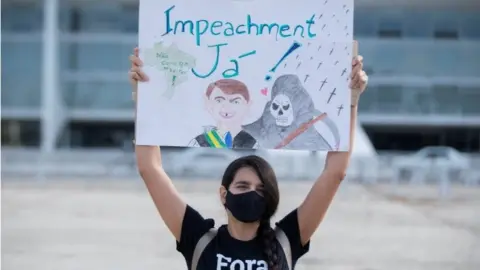 EPA A woman demonstrates against the pandemic management by Brazilian President Jair Bolsonaro, in Brasilia, Brazil, 26 March 2021